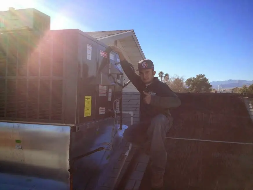 HVAC technician performing HVAC Inspection on a rooftop unit in Lyndon